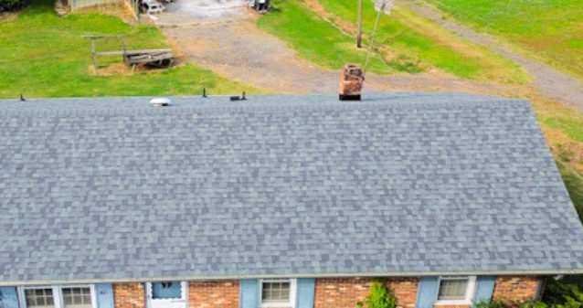The same brick ranch house from the same angle with a new gray shingle roof.