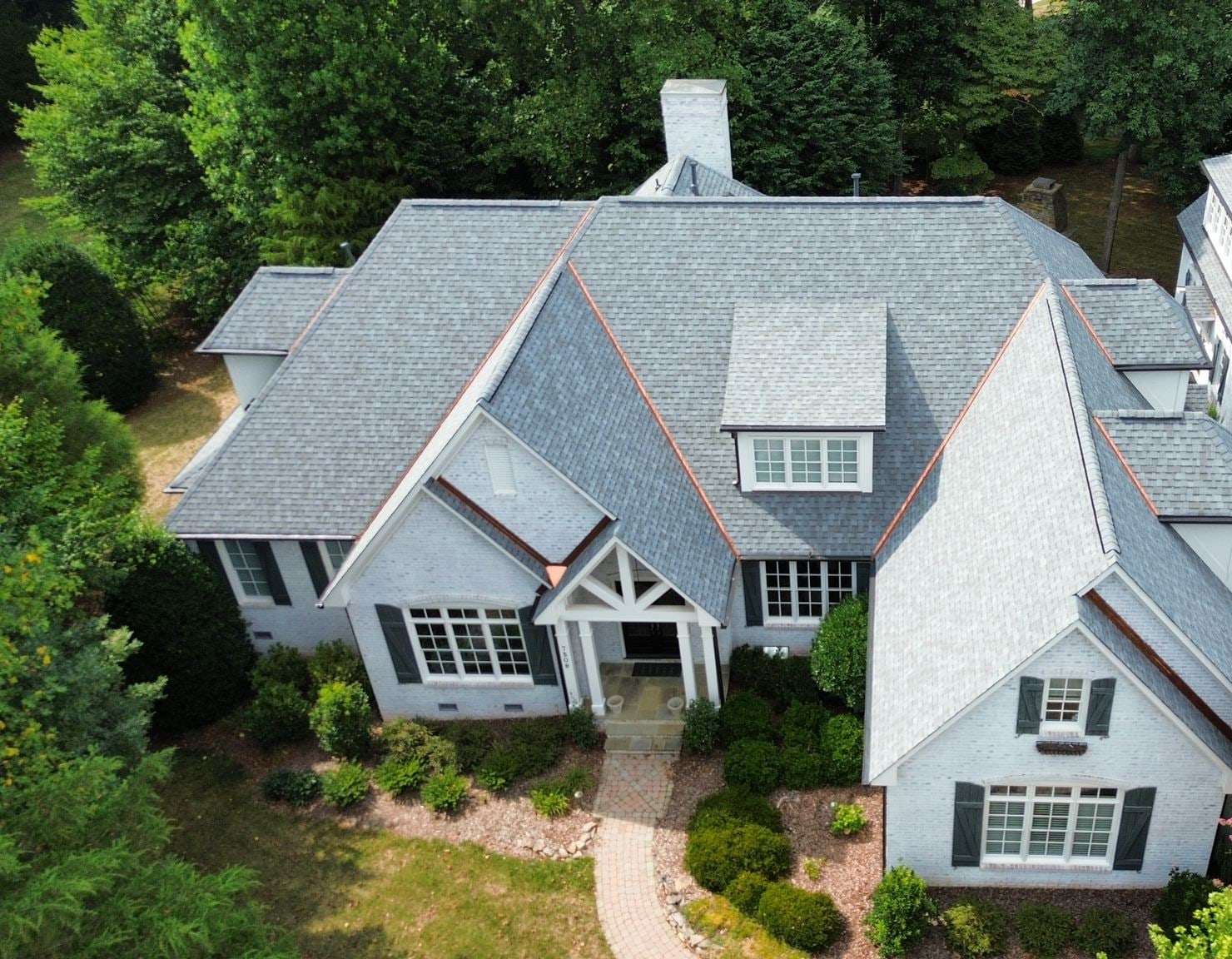 Painted brick home with a new Owens Corning Duration roof in Quarry Gray, seen from above.